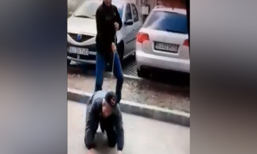 Tânăr ține în lesă un bărbat