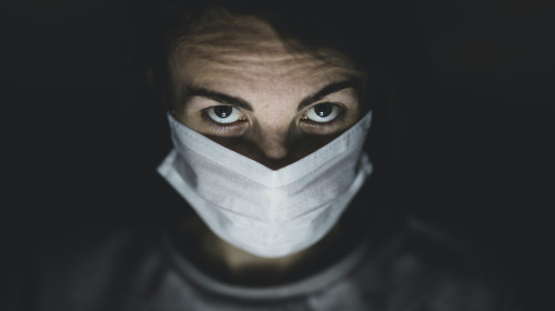 Bărbat tânăr cu mască sanitară pentru COVID-19, coronavirus