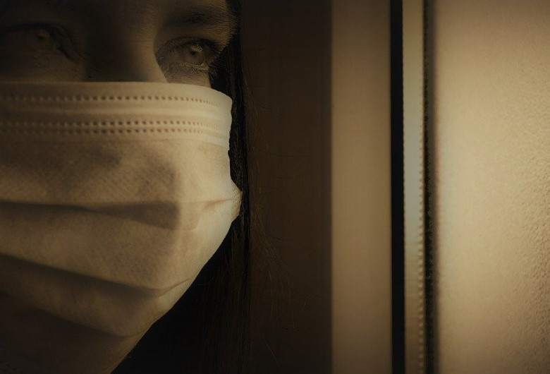 Femeie cu mască sanitară pe față, în izolare la domiciliu, carantină, coronavirus, COVID-19