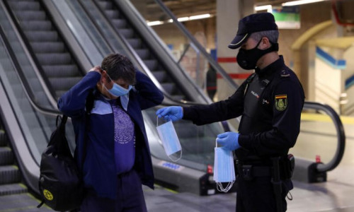 Polițist spaniol îi dă mască de protecție unei femei la metrou în Madrid