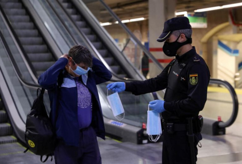 Polițist spaniol îi dă mască de protecție unei femei la metrou în Madrid
