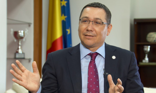 Victor Ponta arătând cu mâinile și zâmbind