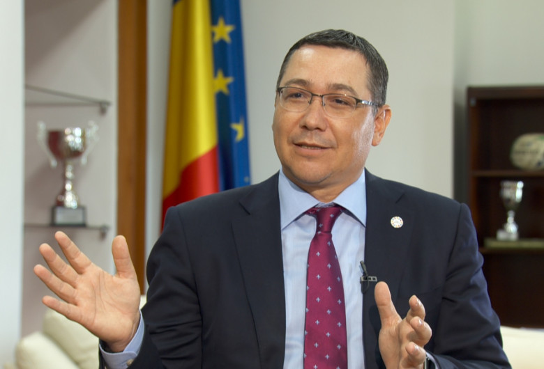 Victor Ponta arătând cu mâinile și zâmbind