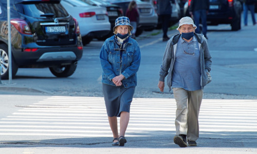 Doi bătrâni fac o plimbare pe o stradă goală, promenadă