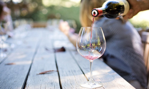Vin turnat în pahar pe o terasă de vară, băutură, relaxare, alcool