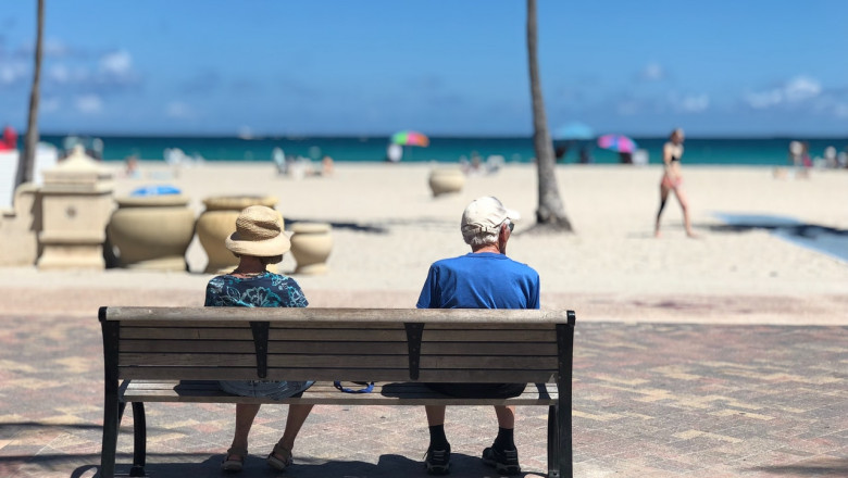Bătrâni, pensionari, moș și babă pe o bancă, la mare, la soare, relaxați, turism, litoral