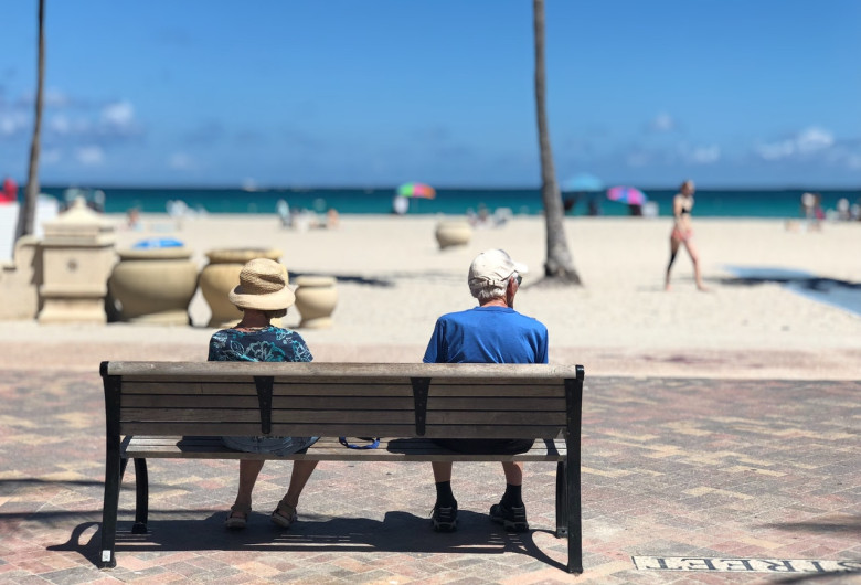 Bătrâni, pensionari, moș și babă pe o bancă, la mare, la soare, relaxați, turism, litoral