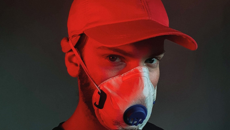 Bărbat tânăr cu mască de protecție pentru coronavirus, COVID-19