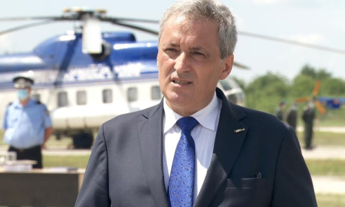 Marcel Vela în fața unui elicopter și a unor polițiști
