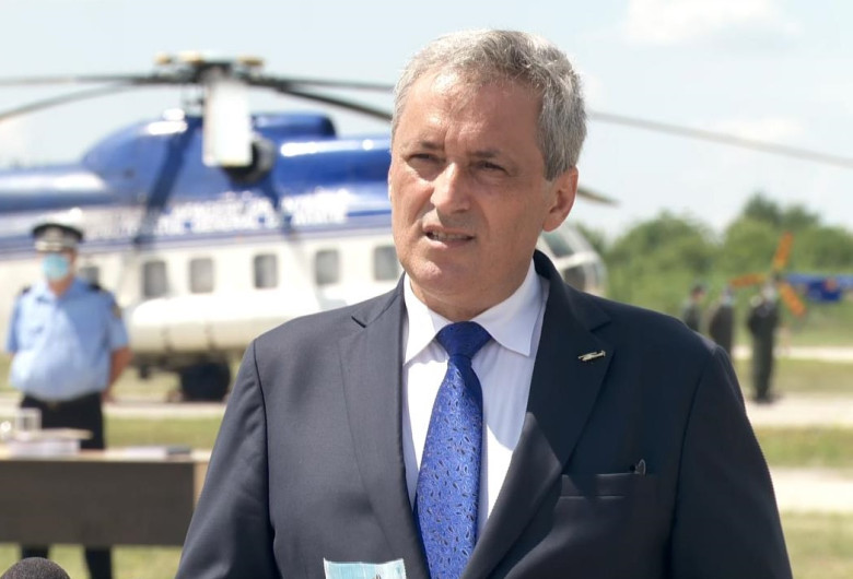 Marcel Vela în fața unui elicopter și a unor polițiști