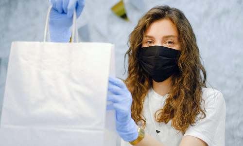 Tânără femeie cu plasă de cumpărături și mască de COVID-19, coronavirus