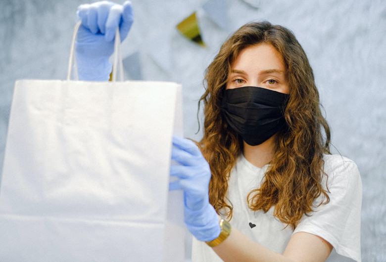 Tânără femeie cu plasă de cumpărături și mască de COVID-19, coronavirus