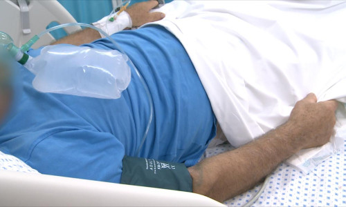 Pacient pe pat de spital, bolnav, cu ajutor respirator, oxigen