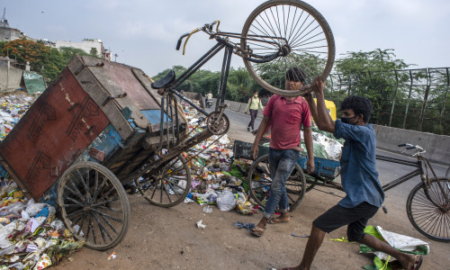 Bărbați caută în gunoaie în India