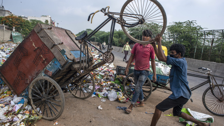 Bărbați caută în gunoaie în India