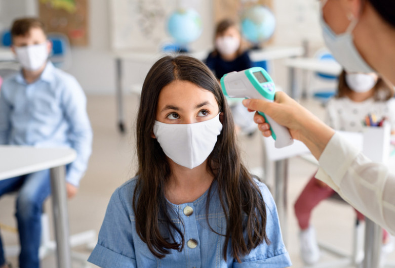 Elevă la clasă, cu profesoară care îi ia temperatura cu termoscaner, educație, mască de protecție, învățământ, ore, cursuri