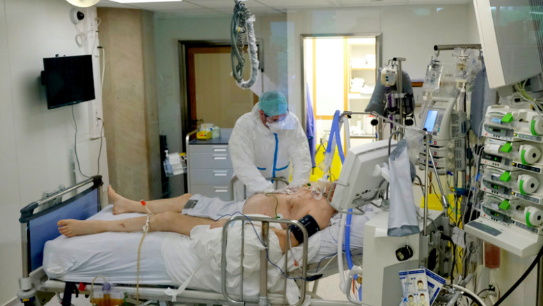 Pacient pe patul de spital, ventilat mecanic cu medic lângă el, tratat de COVID-19, coronavirus, SARS-CoV-2, ATI, terapie intensivă