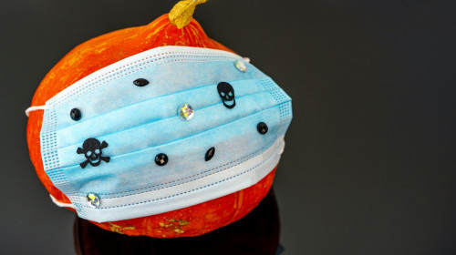 Pumpkin for Halloween with Surgical mask with skulls and rhinestones. Halloween pumpkin head. QUARANTINE, PANDEMIC