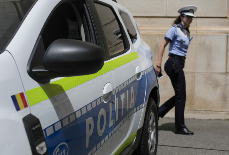 Polițistă lângă mașina de Poliție