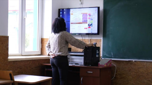 Școala online, profesoară la tablă electronică, digitală, cu cameră video, teleșcoală