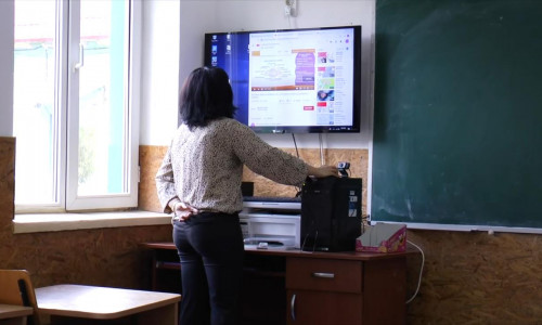 Școala online, profesoară la tablă electronică, digitală, cu cameră video, teleșcoală