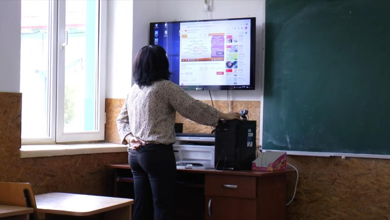 Școala online, profesoară la tablă electronică, digitală, cu cameră video, teleșcoală