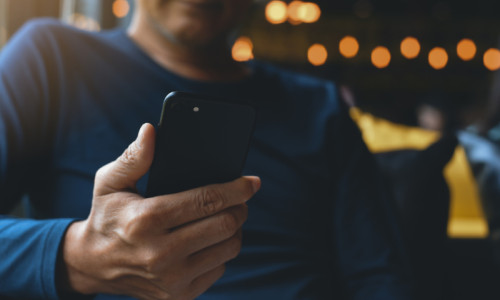 Bărbat se uită la telefonul mobil, smartphone, gadget