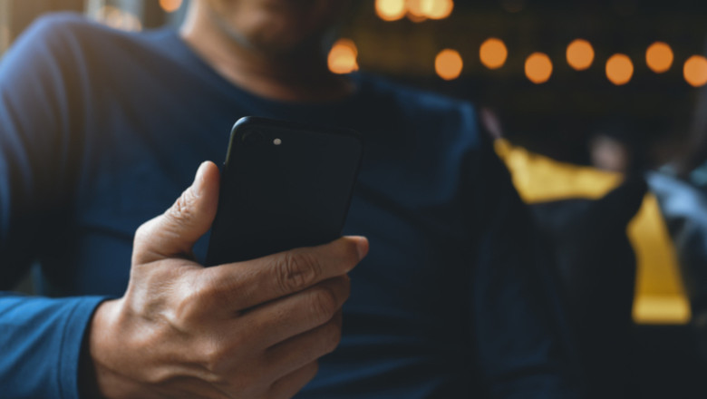 Bărbat se uită la telefonul mobil, smartphone, gadget