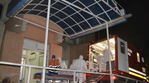 Medical staff dressed in COVID-19 protection gear move one of the COVID-19 patients that where affected by a fire