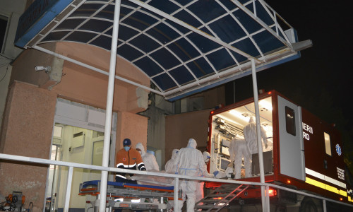 Medical staff dressed in COVID-19 protection gear move one of the COVID-19 patients that where affected by a fire