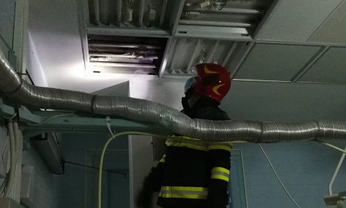 Pompier se uită la un panou de iluminat care a luat foc la Spitalul Județean Cluj