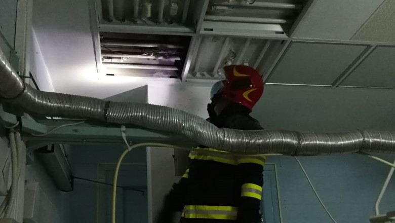 Pompier se uită la un panou de iluminat care a luat foc la Spitalul Județean Cluj