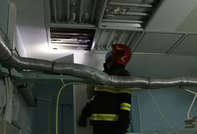Pompier se uită la un panou de iluminat care a luat foc la Spitalul Județean Cluj