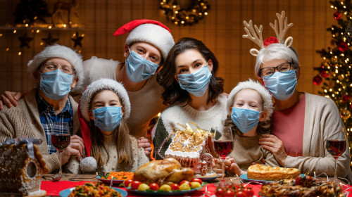 Masă de Crăciun în familie cu mască, sărbători în pandemie cu COVID-19