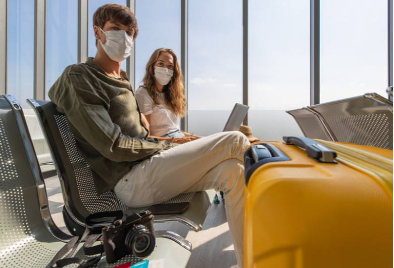 Cuplu de tineri cu bagaje în aeroport în călătorie de turism cu avionul pentru vacanță sau concediu în destinații de relaxare