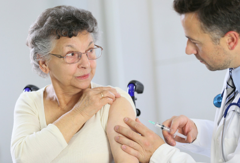 Persoană cu dizabilități, handicap în scaun cu rotile se vaccinează anti-coronavirus, COVID-19, SARS-CoV-2 cu medic, doctor și injecție, seringă, imunizare