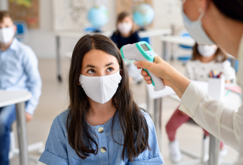 Elevă la școală i se ia temperatura cu termometru de COVID-19, coronavirus, SARS-CoV-2, educație, ore, clase, învățământ