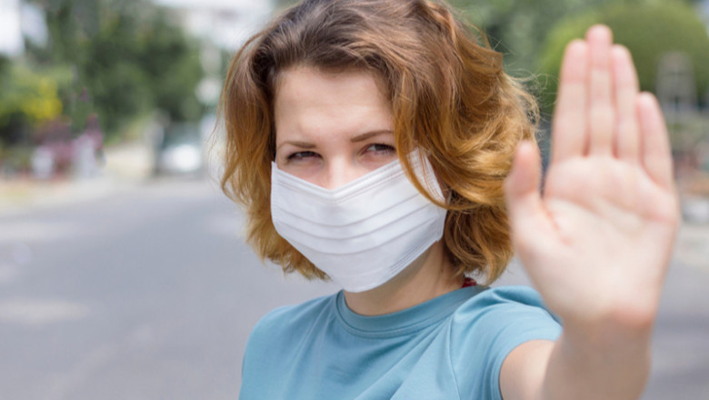 Femeie cu mască anti-COVID-19, coronavirus, SARS-CoV-2 arată mâna de a păstra distanța, fără gripă sau infecții respiratorii