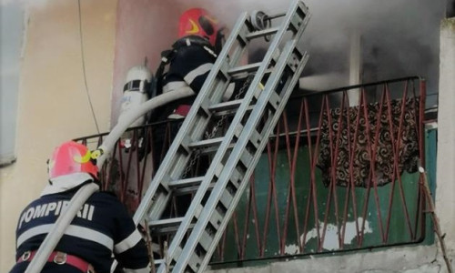 Pompieri ISU cu autoscară la un balcon cuprins de incendiu