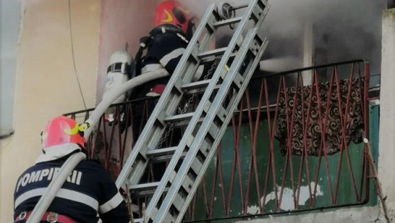 Pompieri ISU cu autoscară la un balcon cuprins de incendiu