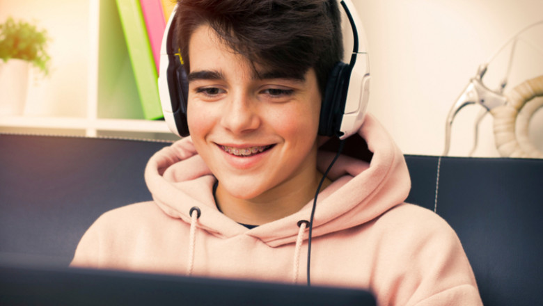 Școala online, băiat cu laptop în față se uită la orice, inclusiv filme porno, zâmbește, râde, imagini, social media, calculator