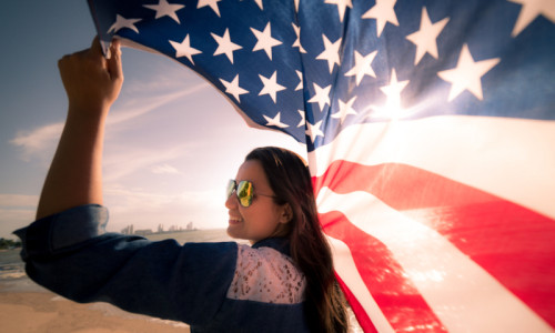 Femeie americană ține în mână un drapel SUA, steag, America, turism