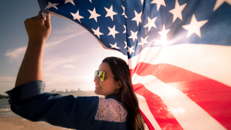 Femeie americană ține în mână un drapel SUA, steag, America, turism