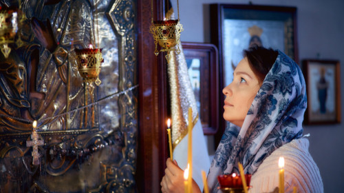 Femeie în biserică ortodoxă, rugăciune, religie, BOR, creștinism, lumânări, credință