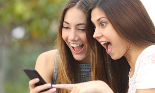 Eleve, tinere, fete surprinse, entuziasmate, fericite cu smartphone, telefonie mobilă, rețea de socializare, aplicații, vești, știri, subiecte postate, fițuică, copiuțe, evaluare, educație