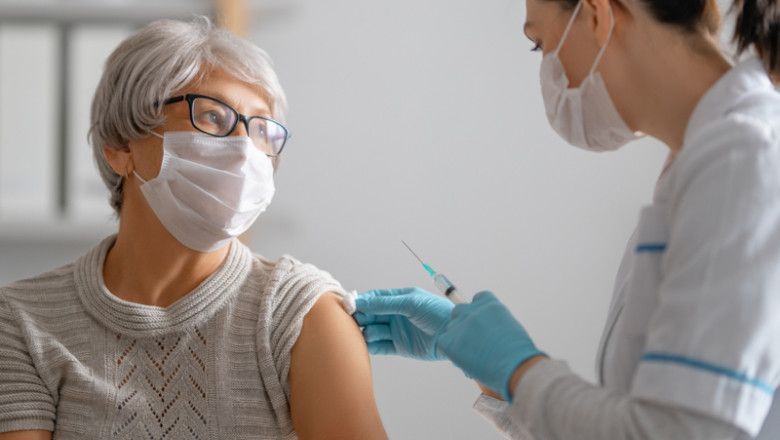 Femeie vârstnică bătrână babă vaccinată cu ser din doză anti-COVID-19 coronavirus, SARS-CoV-2, injecție cu seringă de la doctoră asistentă, imunizare