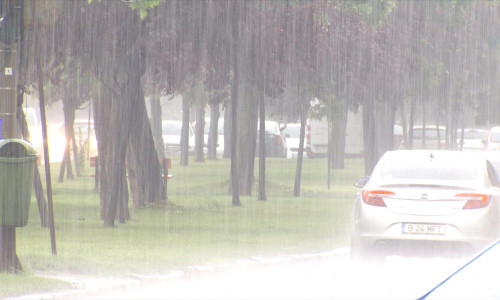 Plouă mult cu ploaie torențială din precipitații pe stradă cu mașină auto, bălți în rutier, furtuni cu averse și căderi de apă