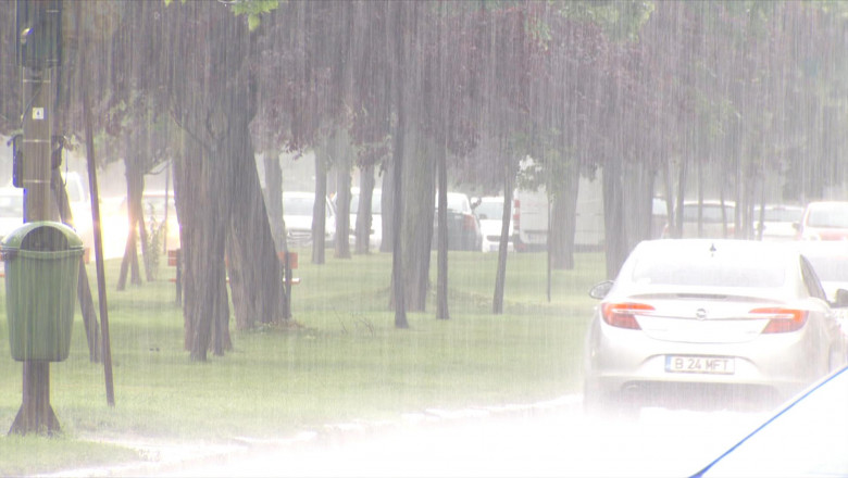 Plouă mult cu ploaie torențială din precipitații pe stradă cu mașină auto, bălți în rutier, furtuni cu averse și căderi de apă