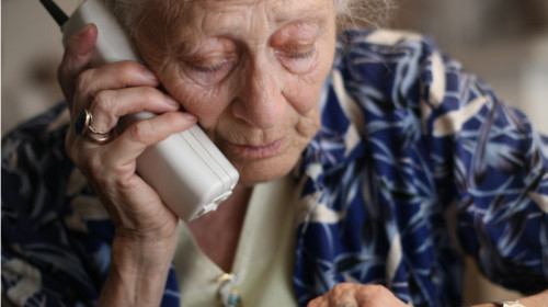 Bătrână, babă, hoașcă vorbește la telefon, amărâtă, tristă, supărată, jefuită