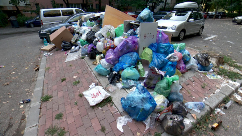 Gunoaie și deșeuri aruncate într-o parcare, pe stradă, poluare, saci cu resturi menajere